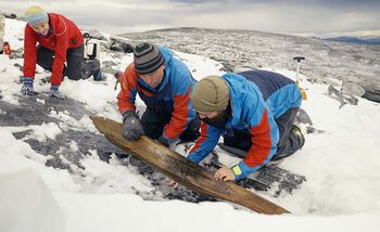 The ski was found upside down. Here it is turned over and we see the upper side with the binding. From the left, archaeologists Espen Finstad, from Secrets of the Ice, Innlandet County Municipality, and Julian Post-Melby, from the&amp;#160;Museum of Cultural History.