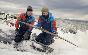 Cheerful archaeologists viewing the newly found ski. Archaeologists Espen Finstad (Secrets of the Ice/Innlandet County Municipality) on the left and Julian Post-Melby (Museum of Cultural History) on the right.