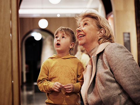 Bestemor og barnebarn besøker museet sammen.