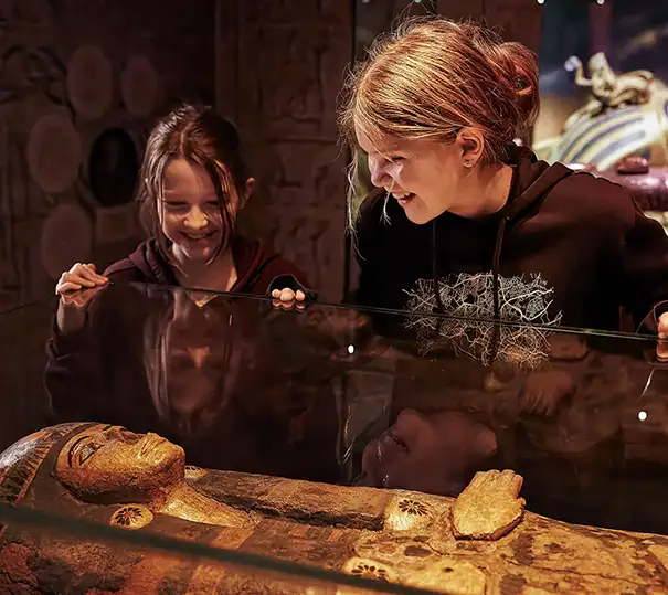 Two girls studying a sarcophagus
