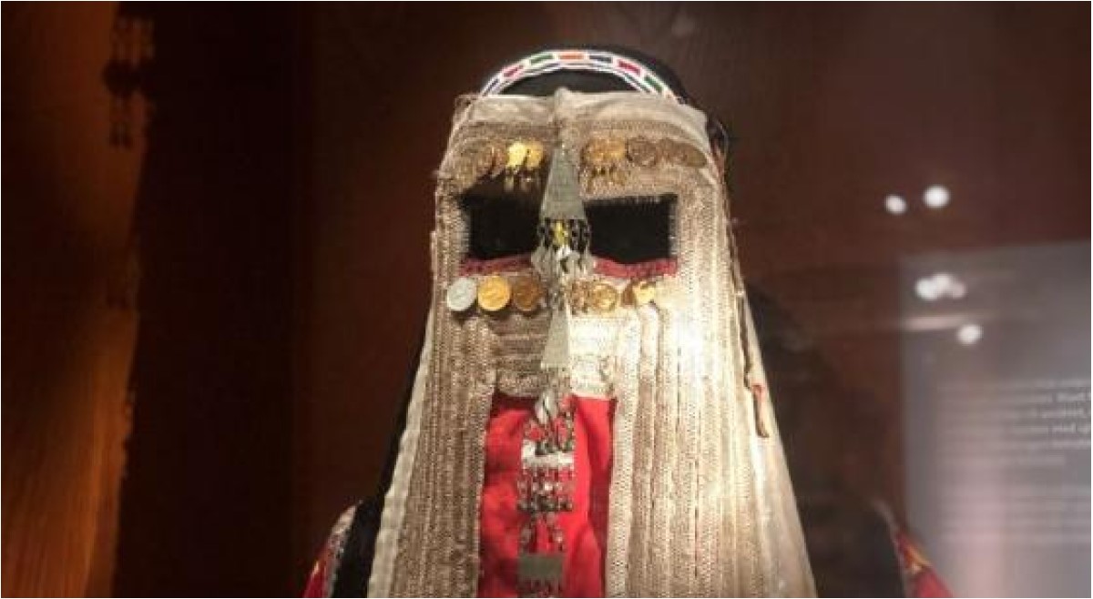 Mask made of white and red fabric decorated with jewelry