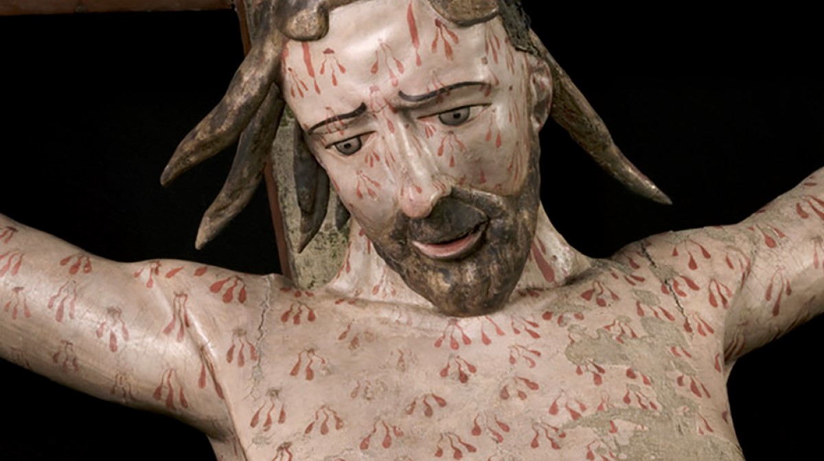 Utsnitt av treskulptur av Jesus som henger på korset