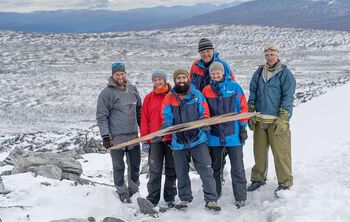 Hele arkeologteamet samlet med skien. Fra venstre: Dag Inge Bakke og Mai Bakken, begge fra Norsk fjellsenter, Julian Post-Melbye, fra Kulturhistorisk museum, Øystein Rønning Andersen og Runar Hole, begge fra Secrets of the Ice-prosjektet. Bak står Espen Finstad, også fra Secrets of the Ice-prosjektet.